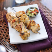 two grilled chicken sishkabobs with cucumber salad two grilled chicken sishkabobs with cucumber salad