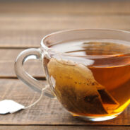 Tea bag in a glass cup on a brown wooden background. to make tea